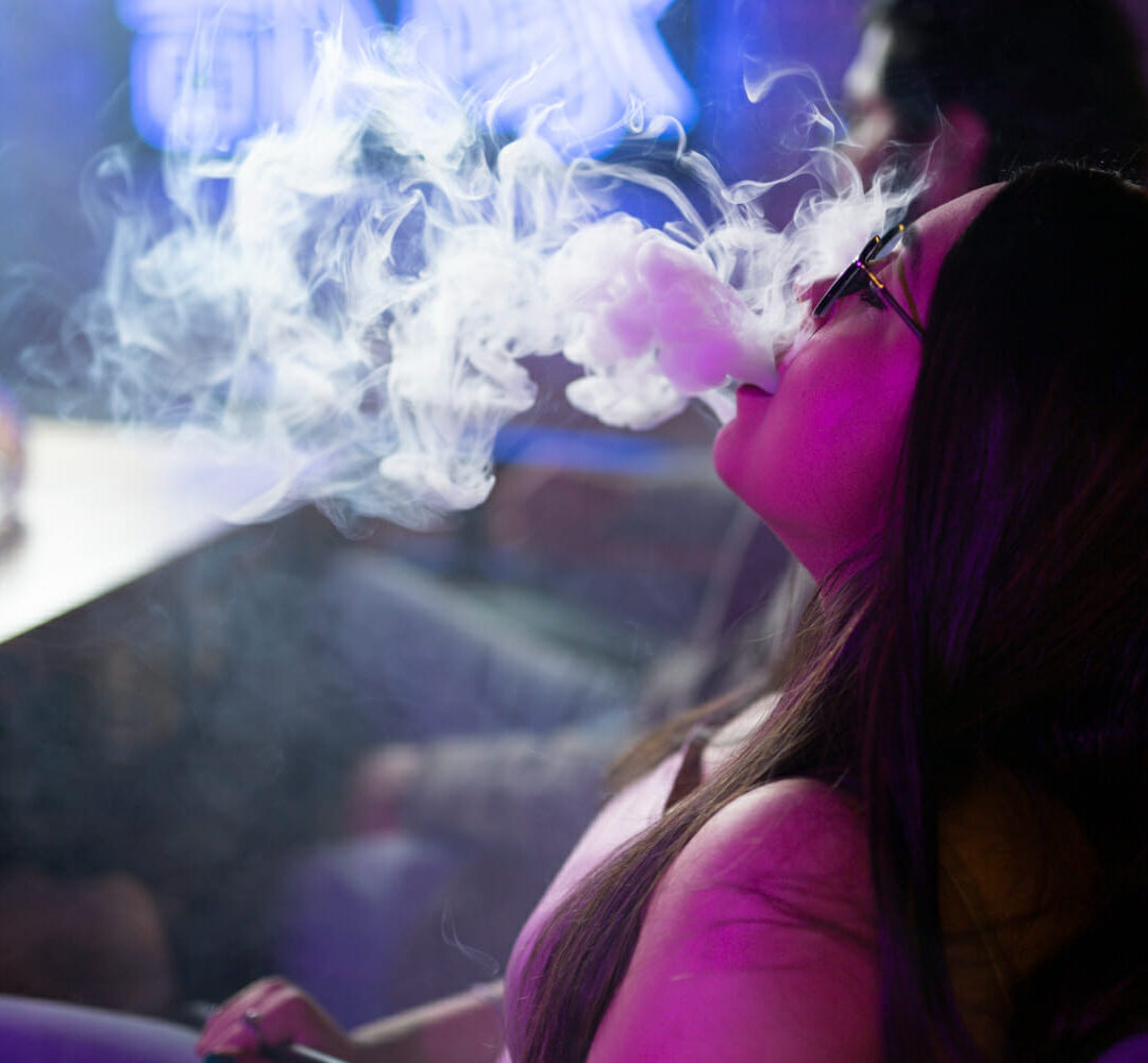 在水烟酒吧抽电子烟放松的女人